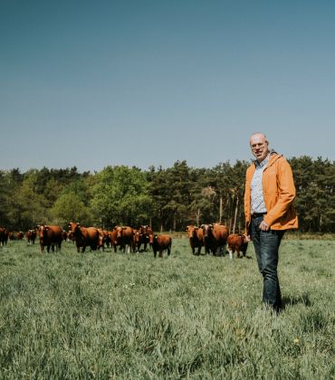 Eigenaar Johan Martens staat voor zijn koeien op het terrein van zorgboerderij Hemelrijksche Hoeve.