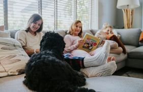 Gezin zit gezellig samen op de bank, met de hond